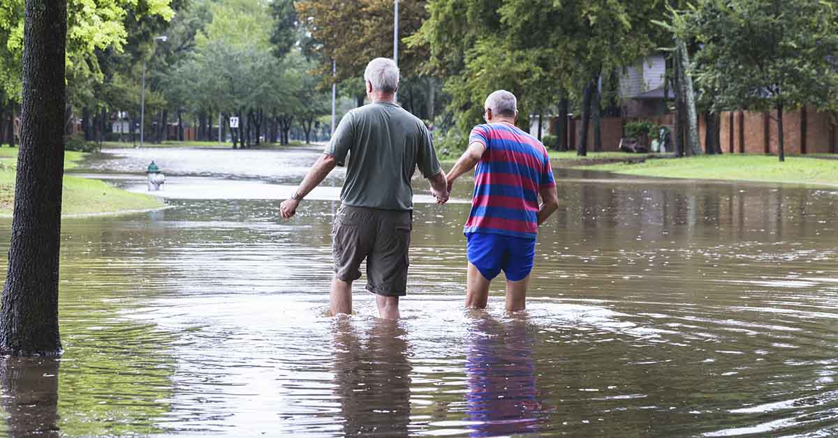 two men walking through flooded area