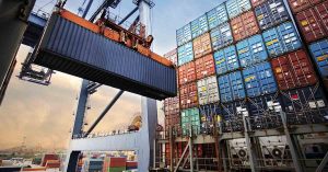 Global Tariffs and Their Threat to U.S. Prices: A Complete Guide shipping containers being moved around at a shipping and receiving yard. Global trade concept