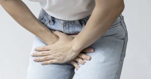 Understanding UTIs: A Guide to Women’s Health and Prevention Woman with hands placed over groin area due to UTI pain