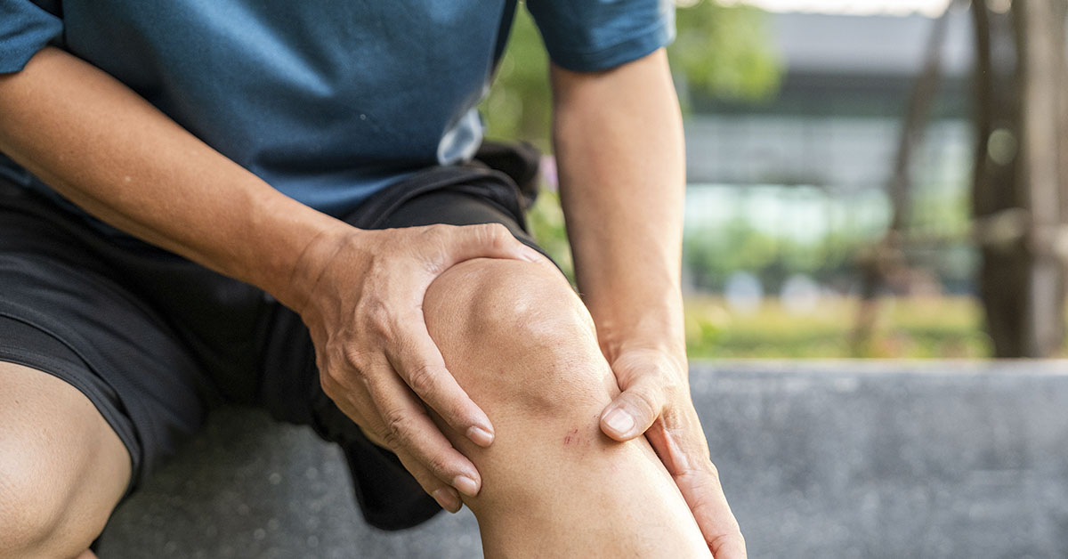 man holding his knee due to sore joints. Joint health concept