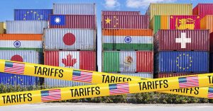 5 Things to Grab Before Trump’s Tariffs Hit on August 1st Shipping containers with various contries flags on them with yellow tape showing an American flag and the word Tariffs. Tariff concept