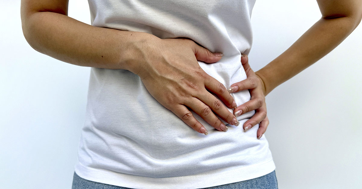 woman holding side due to abdominal pain