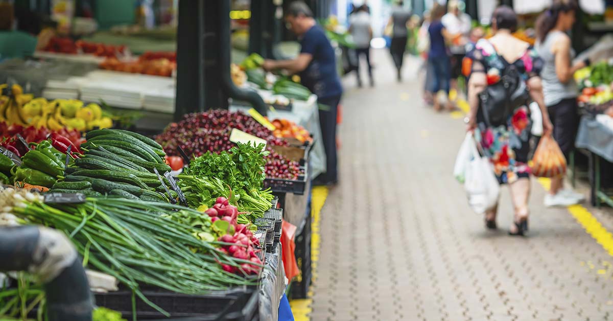 Market showing various stalls and vendors selling produce