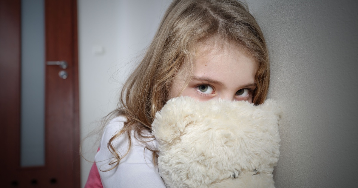 Young sad girl hugging a teddy bear