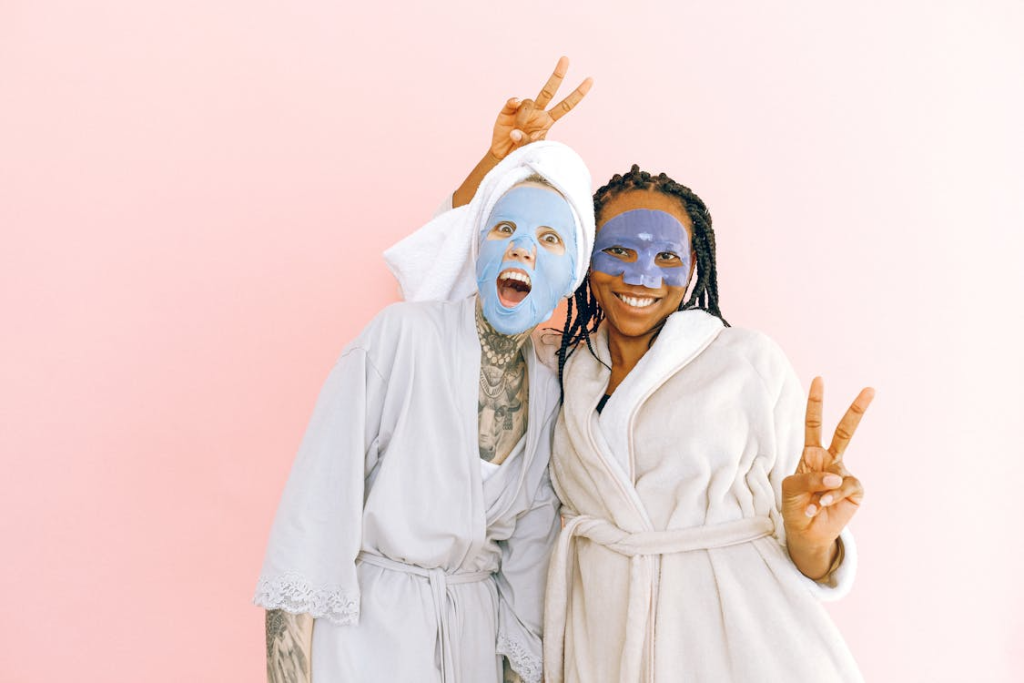 Happy multiethnic female friends in sheet masks showing peace gesture