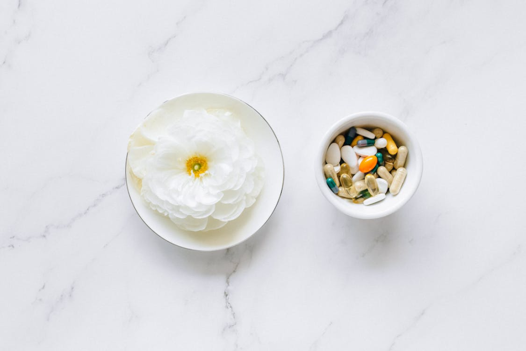 White Ceramic Bowls With White Flower and Medicines on Marble Table
