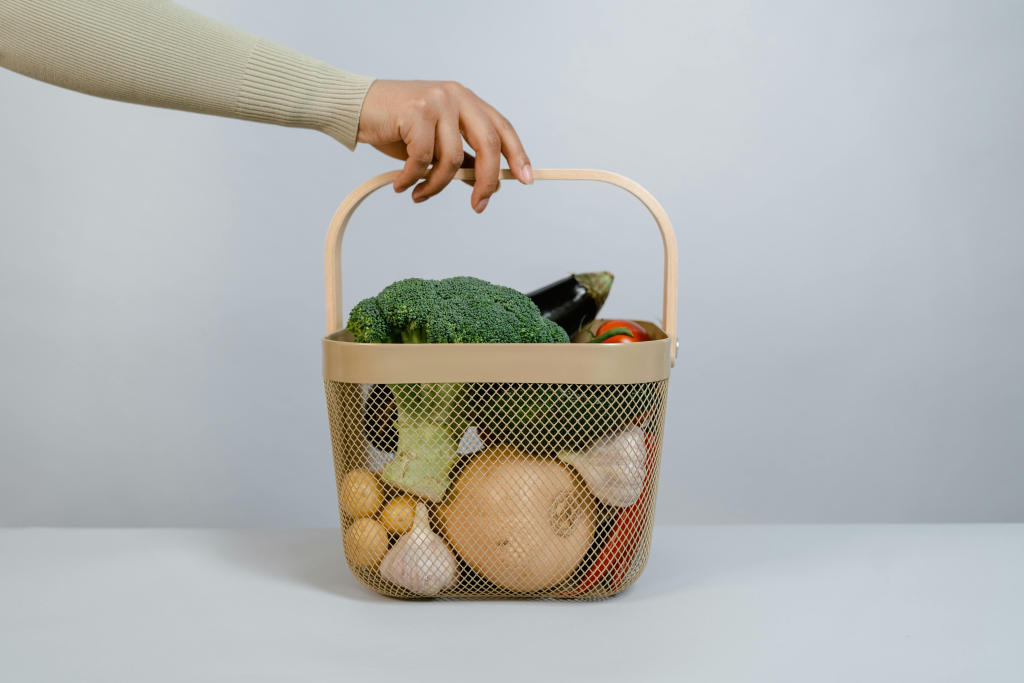 Woven basket filled with fresh vegetables including broccoli, onions, and root vegetables that provide protective fiber.