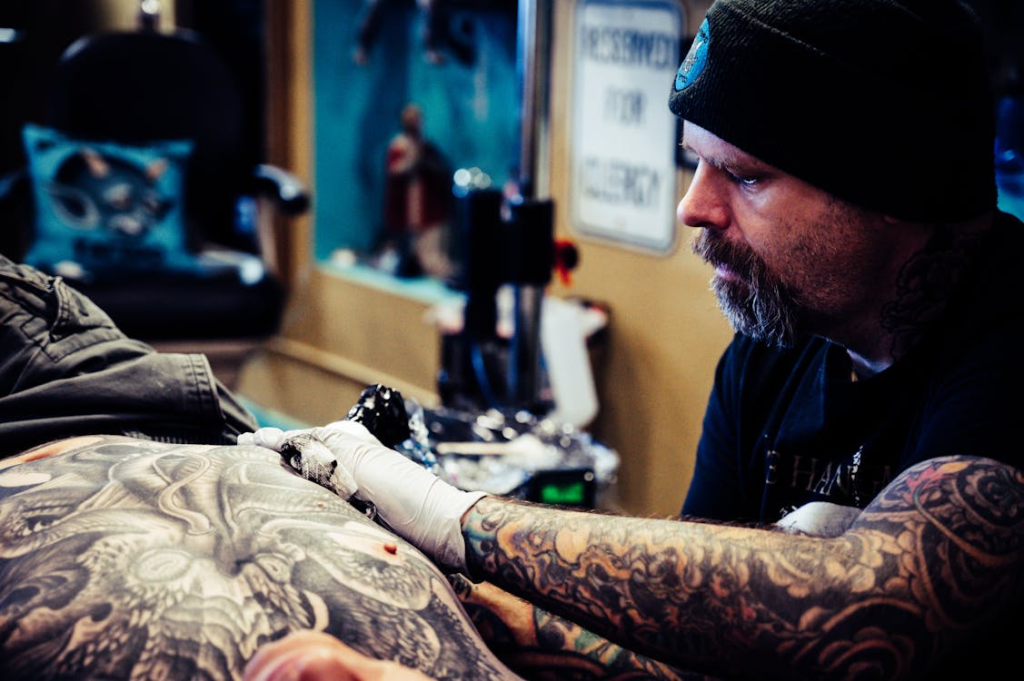Man Doing Tattoo Inside Room
