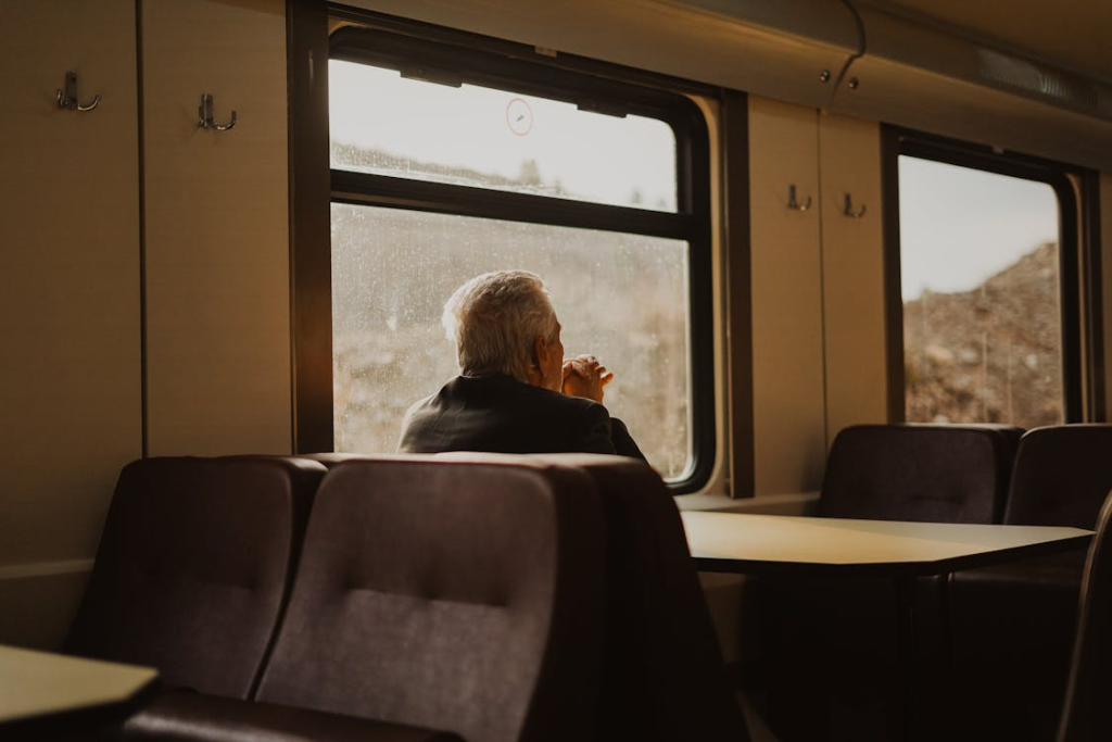 Elderly Man Travelling by Train and Seating by the Table