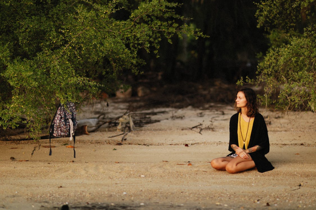 Woman Sitting on Sand at the Beach
