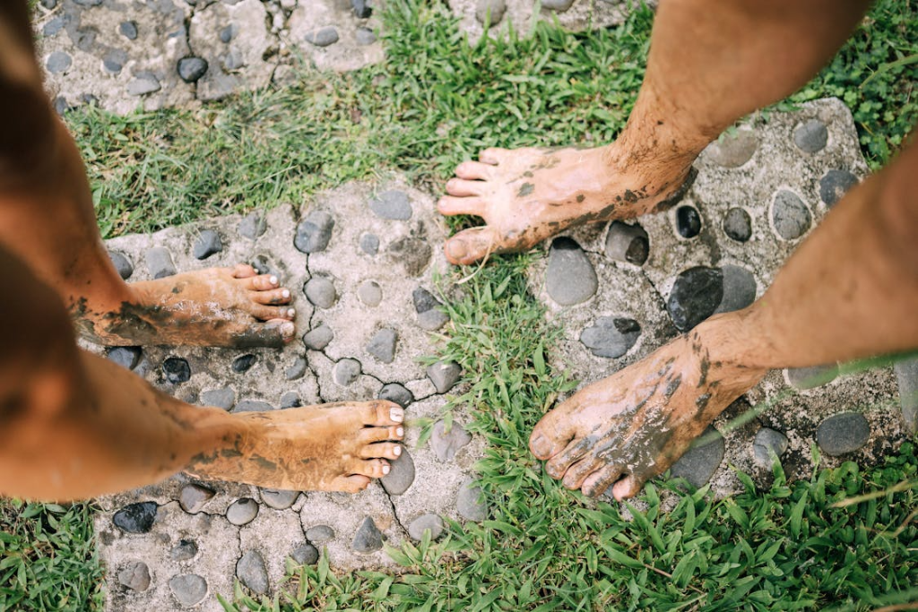 Close-up of Mans and Womans Dirty Feet Covered in Mud 
