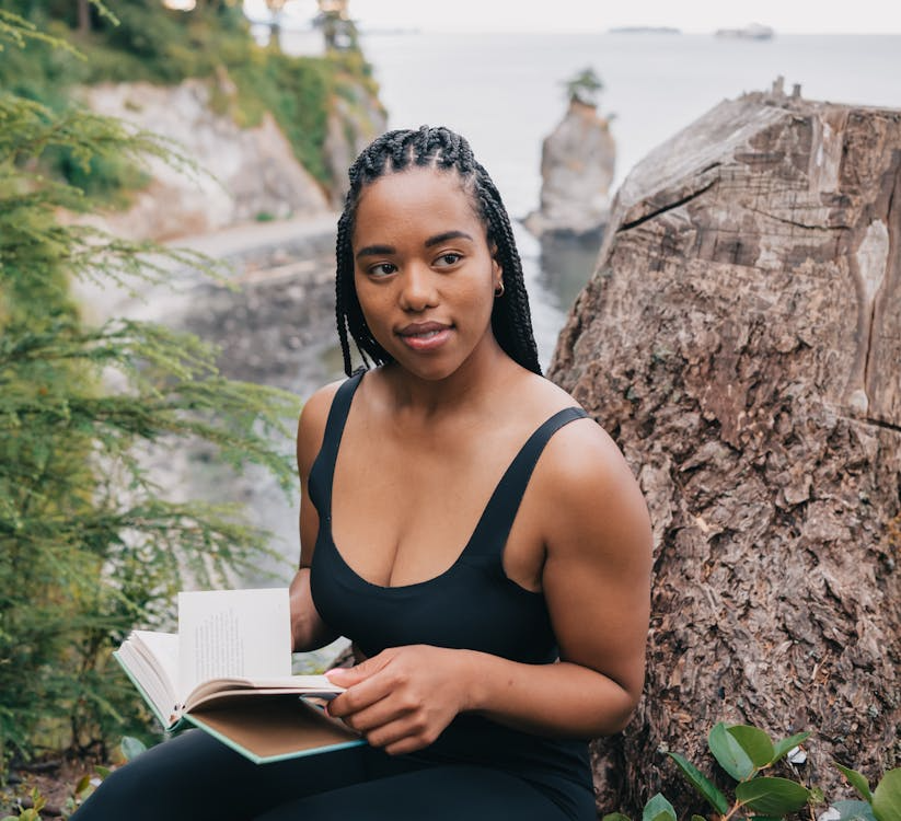 Woman in Black Activewear Holding a Book

