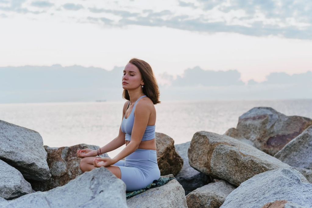 A Woman Doing a Meditation near the Ocean during Morning
