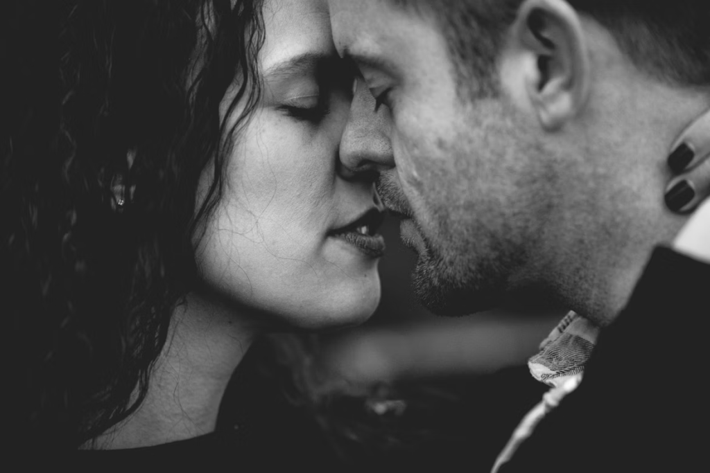 Black and white intimate portrait captures the moment before a kiss, millions of years of evolution contained in one gesture.