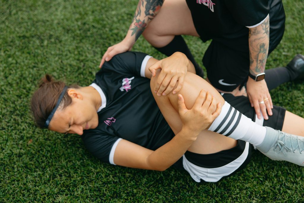 Injured Woman Lying on Grass Field
