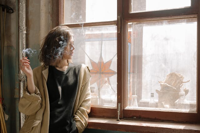 person smoking joint at window