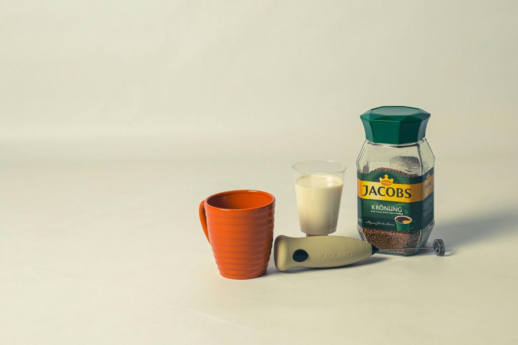 Instant Coffee and a Milk Frother beside a Cup
