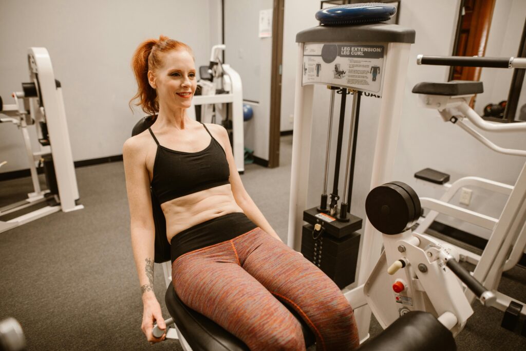 Middle-aged, red haired woman using a gym machine