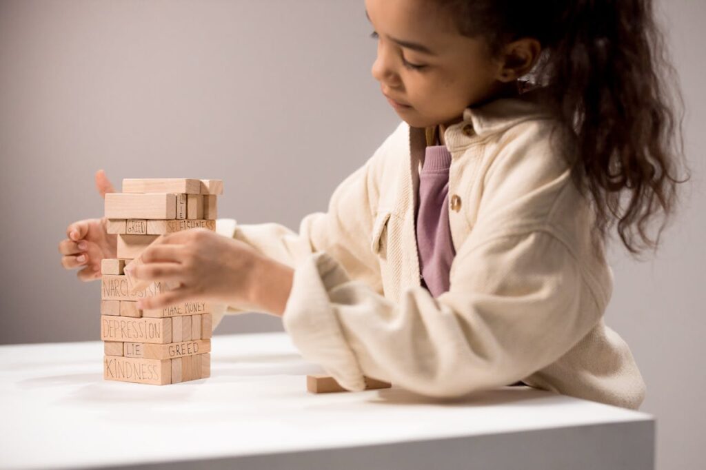 A Girl Playing with Wooden Building Blocks with Words
