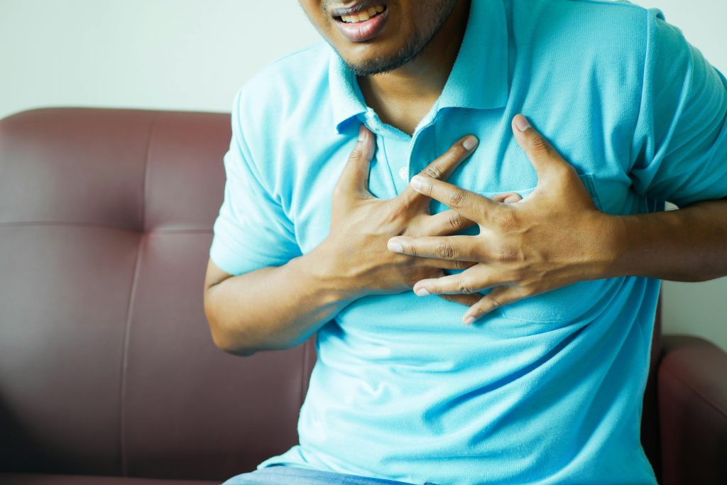 Close-up of a Man in Blue Polo Shirt with Hands on Chest
