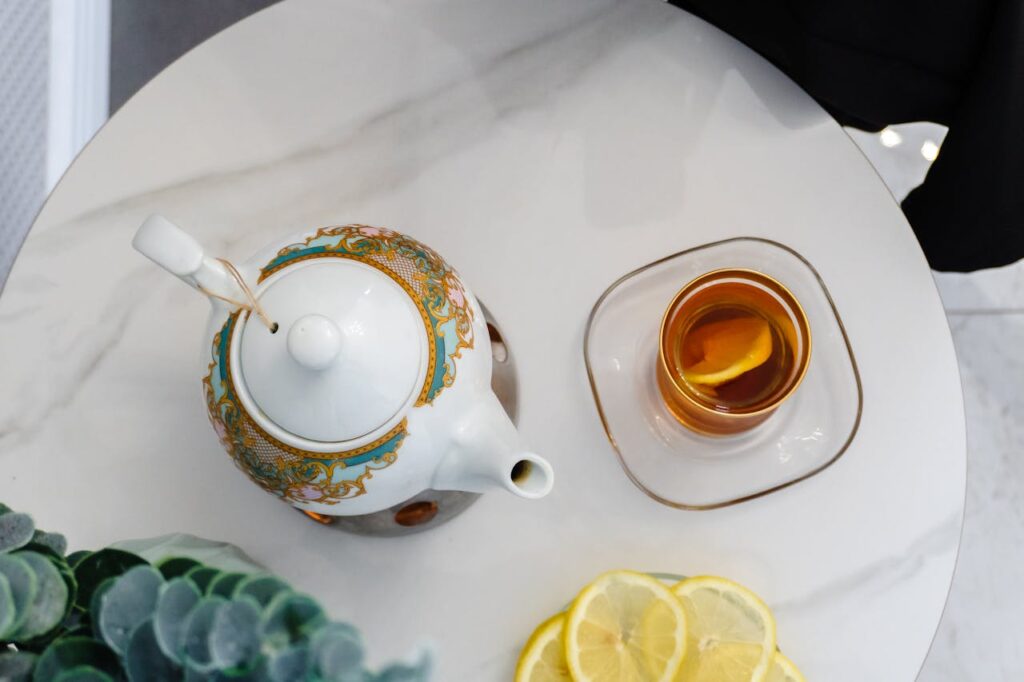 Elegant Tea Setting with Decorative Teapot and Lemon Slices
