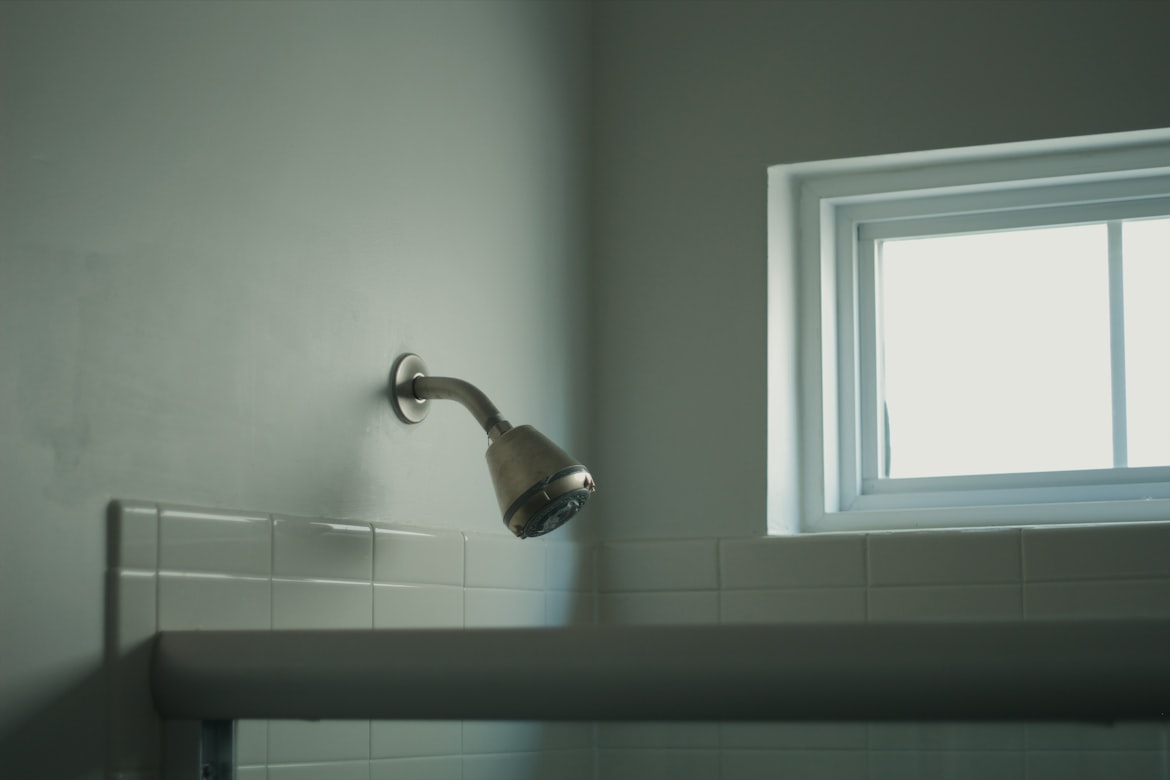 Clean, minimalist bathroom with shower, representing proper hygiene practices for infection prevention.