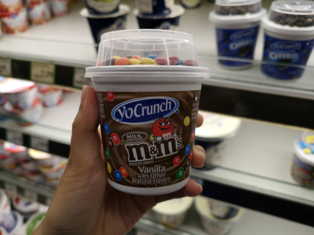Subang Jaya, Malaysia - 7 May 2018 : Hand hold a container of M&M yogurt with chocolate candies in the supermarket.
