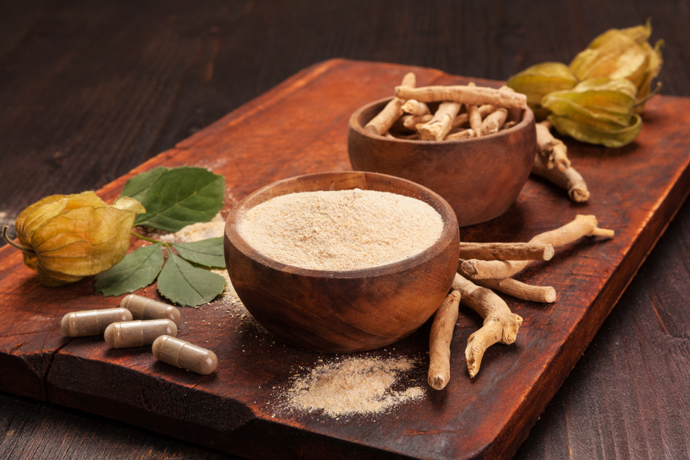 Roots and powder of Ashwagandha also known as Indian ginseng on wooden background. Hair loss, anti cancer, testosteron and depression benefits.

