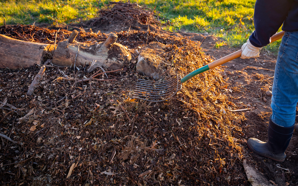 Person Building Permaculture Hill Mound Using Pitchfork in the Meadow