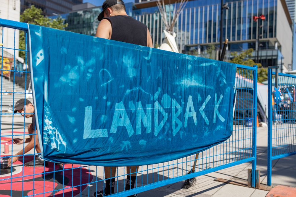 Vancouver, Canada - July 1,2022: View of sign Land Back as part of protest against celebration of Canada day in front of Vancouver Art Gallery