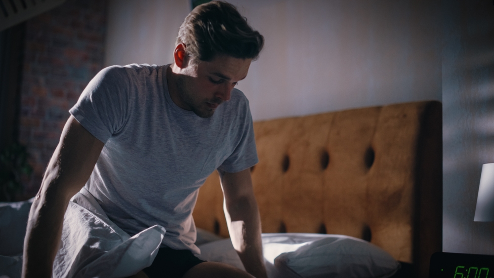 Man Wakes Up, Turns off Alarm Clock with Frustration, after Sleepless Insomniac Night. Early Rising Stressed Man Ready to Face Day of Problem Solving. He is Tired, Upset
