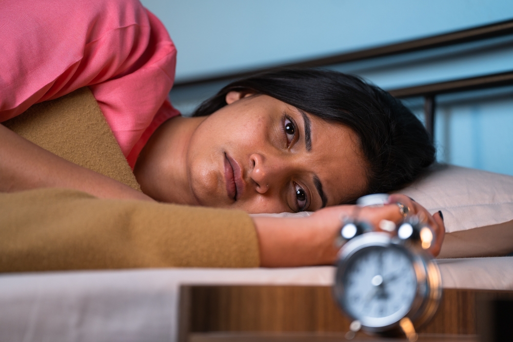 young girl unable to sleep at night due to insomnia - concept of health care, illness and nightmare or depression.