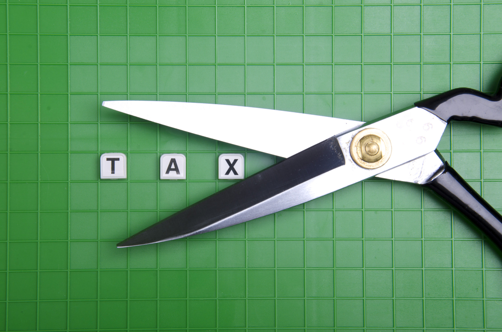 Alphabet TAX with scissor on the green box platform