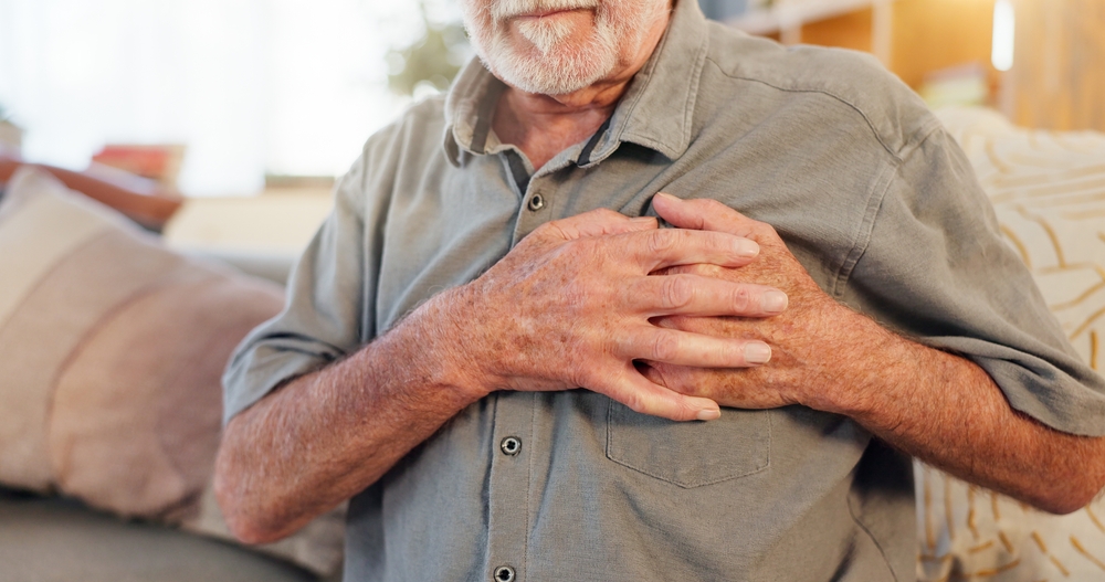 Old man, home and hands on chest for heart attack, pain and hypertension stress or lung fail. Elderly person, medical issue and cardiovascular disease or artery pressure, asthma and cardiac arrest