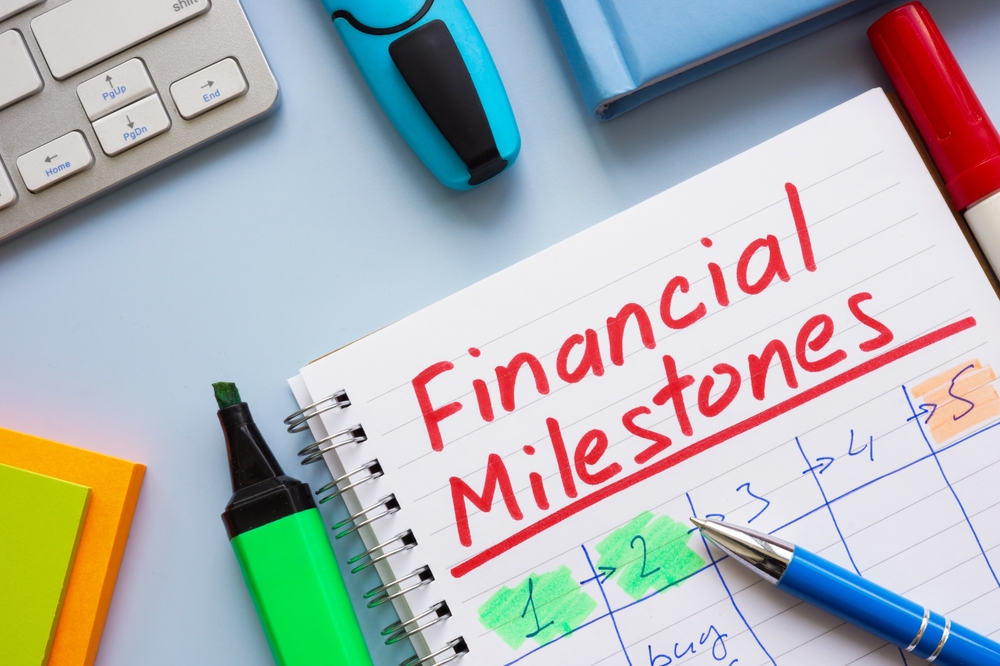 Notebook with notes and the words Financial Milestones symbolizing goal setting and financial planning.