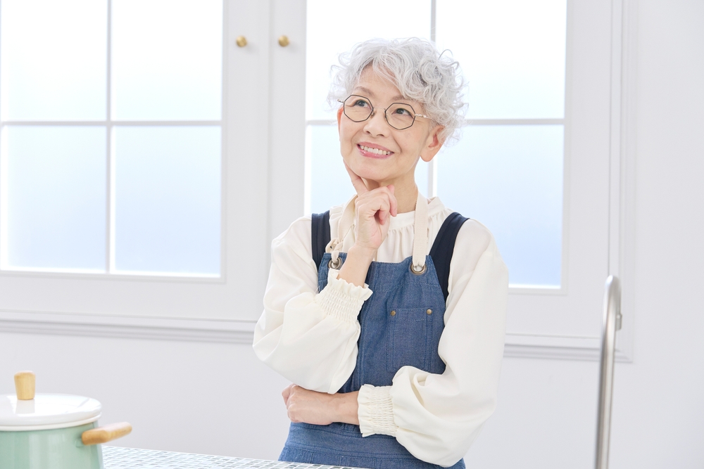 Asian senior woman thinking at the kitchen