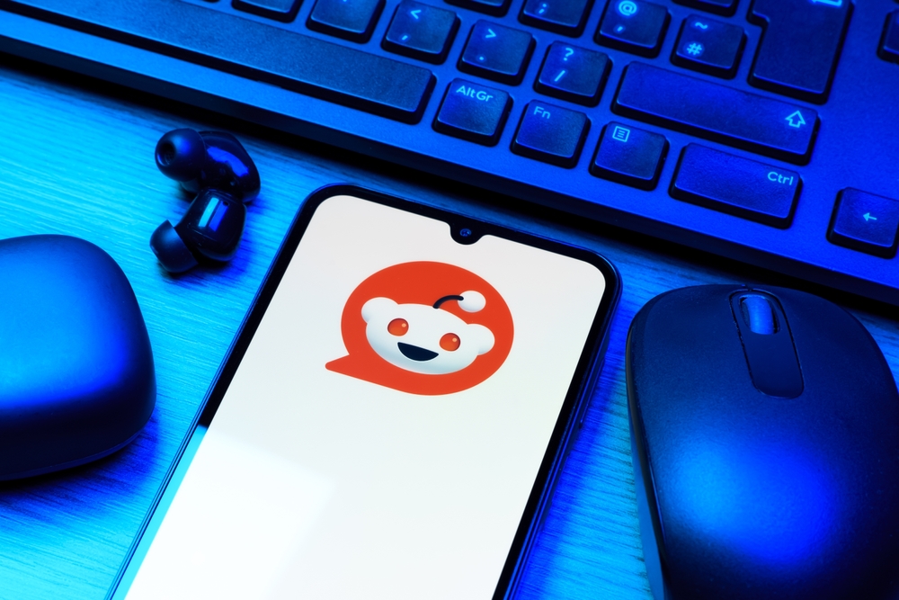 Prague, Czechia - 10 21 2024: Smartphone on surface showing Reddit logo.