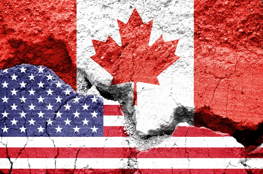 US American and Canadian flags on cracked background. Concept of diplomatic crisis, tariffs and commercial trade war between United States and Canada