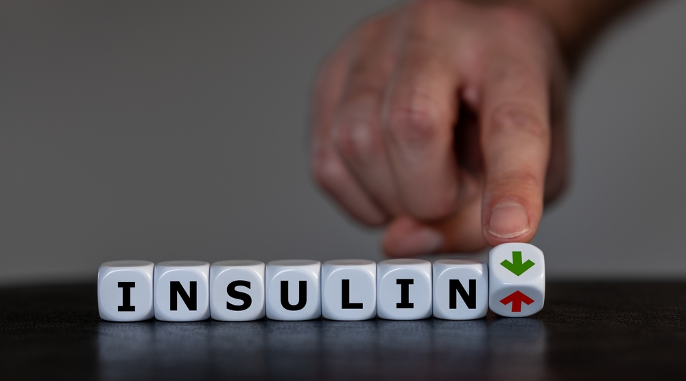 Symbol for reducing insulin by eating healthy food. Hand turns dice and changes the orientation of an arrow from up to down next to the word insulin.