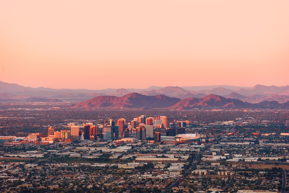 Phoenix Arizona with its downtown lit by the last rays of sun at the dusk.
