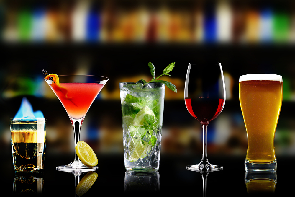 Selection of best selling drinks beer glass of wine cocktails martini mojito and shot short bar blurred background
