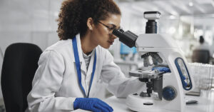 Scientists Discovered a 90,000-Year-Old Girl Born from Two Different Species female scientist using a microscope