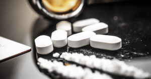 white tablets and lines of white powder. Street and hard drugs concept