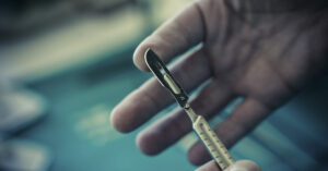tip of thumb pressing against tip of surgical scalpel