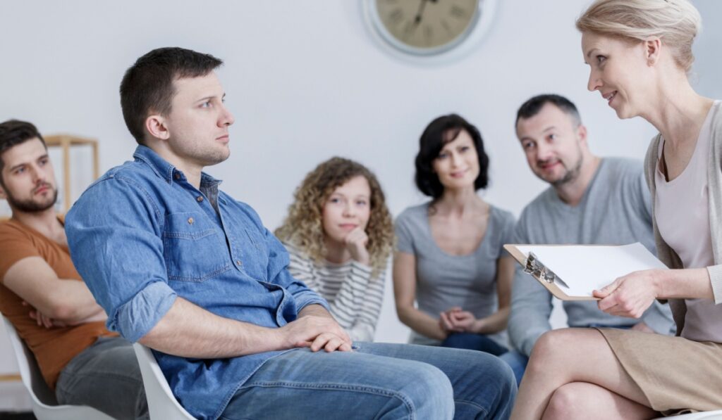 Serious patient looking at his therapist during an anger management class
