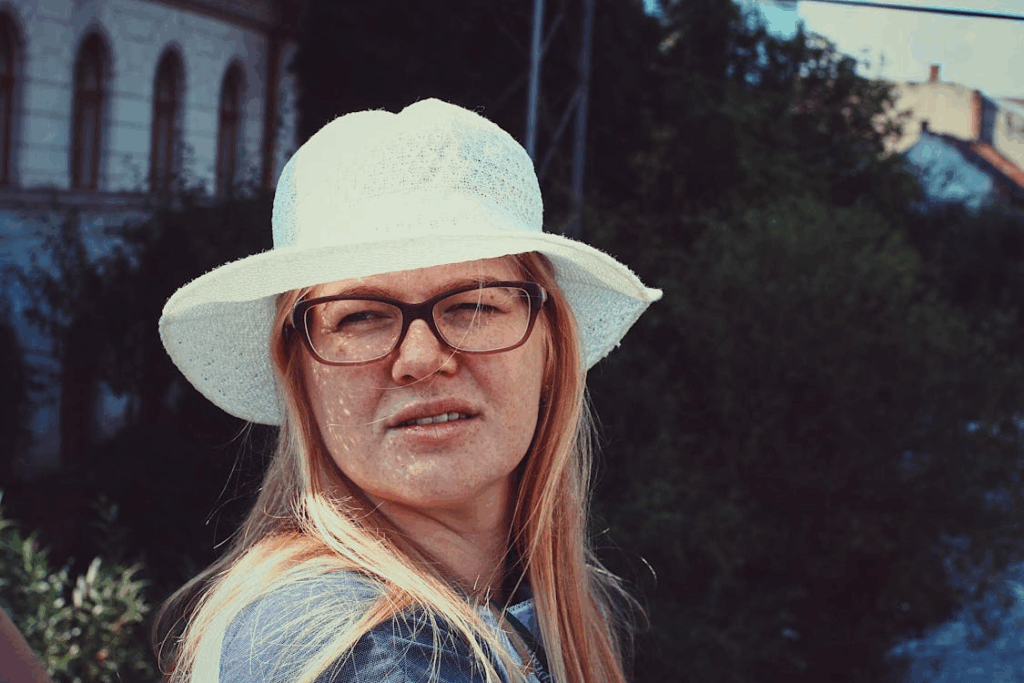 Close-up Photo of Freckled Woman in White Sun Hat and Glasses