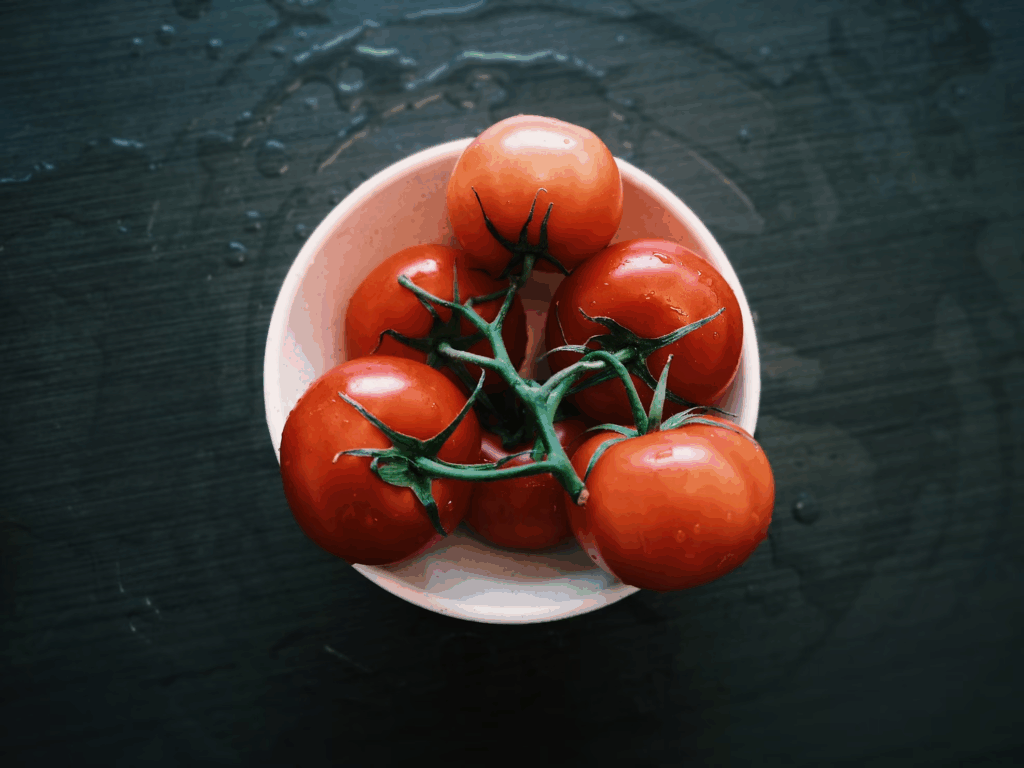 a bowl of tomatoes on the vine