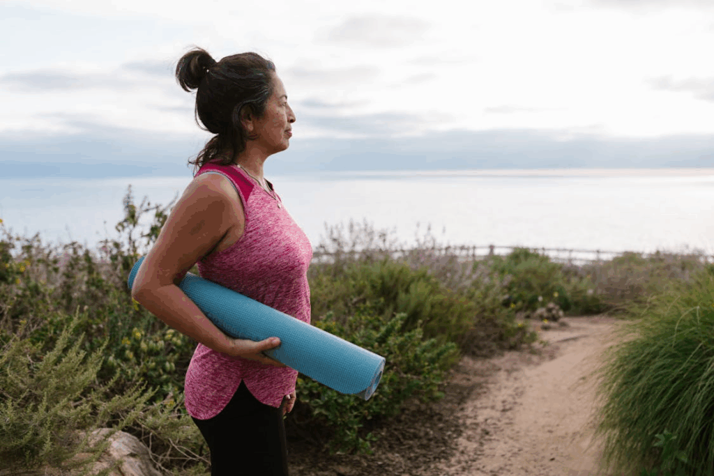 Woman with Yoga Mat on Coastline