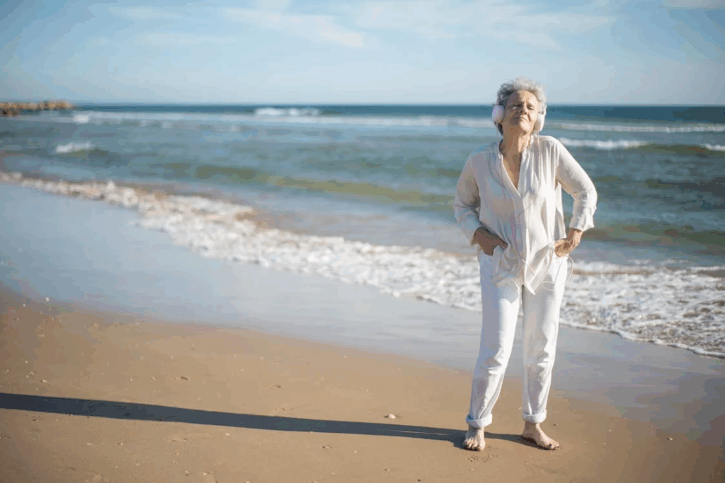 Elderly Woman Standing on Shore While Listening to Music