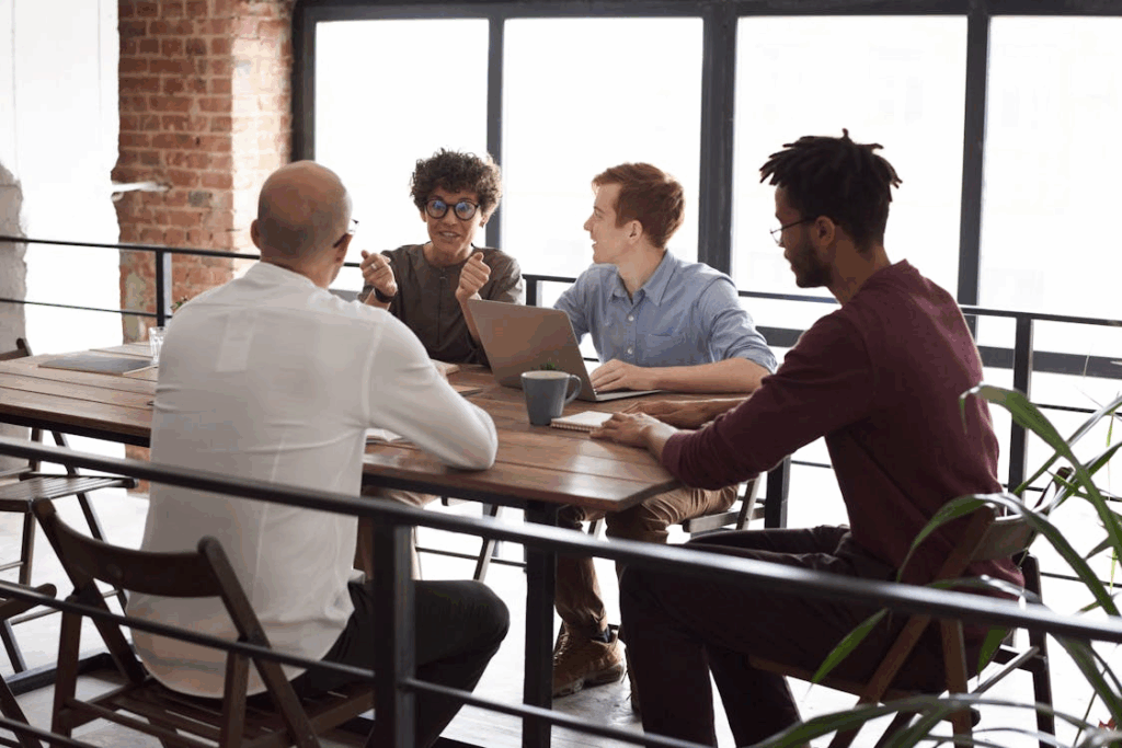 Photo Of People Sitting Near Wooden Table